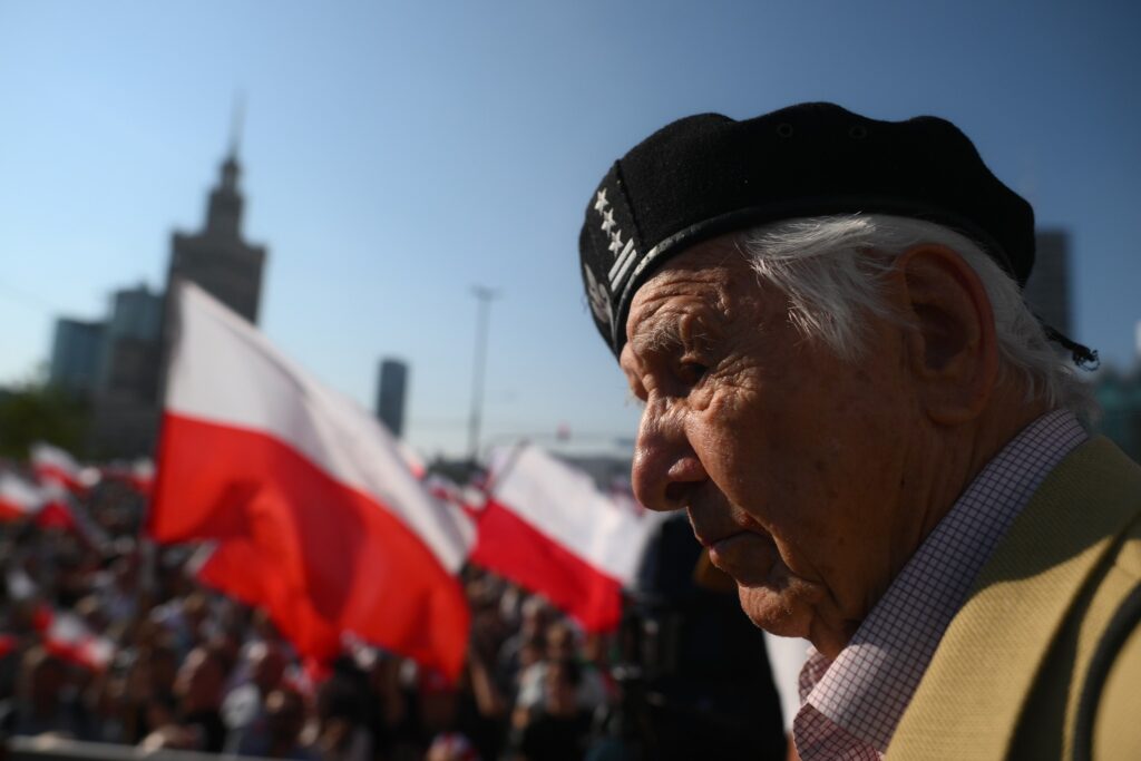 Marsz Powstania Warszawskiego. Weteran na tle pozostałych uczestników manifestacji